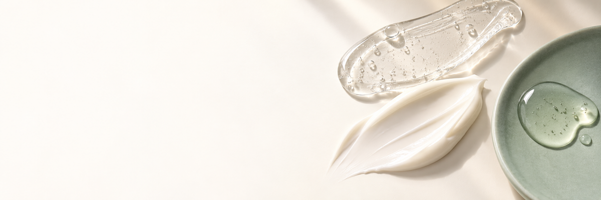 Texturas de gel, sérum y crema sobre una superficie marfil con detalle salvia