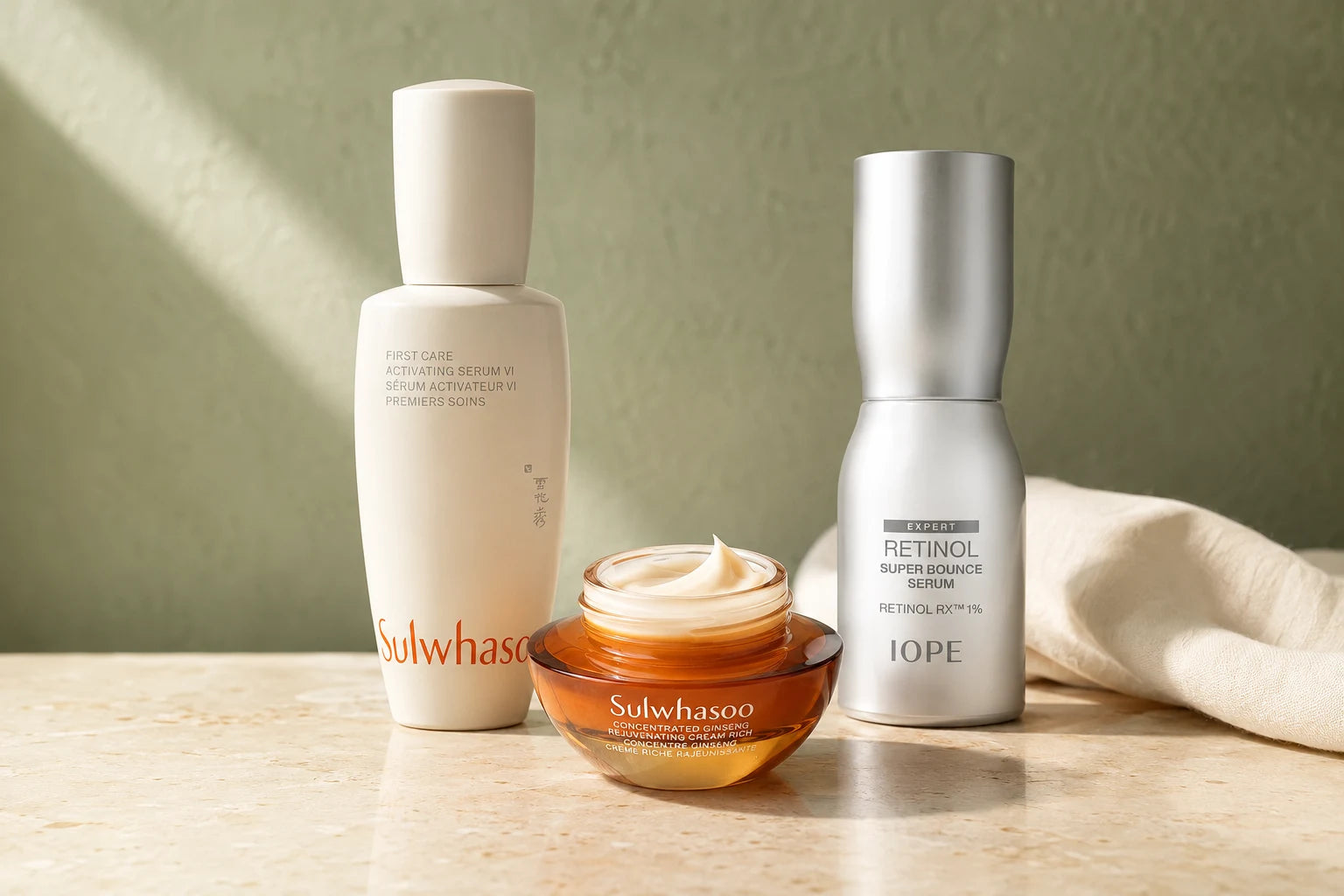 Sulwhasoo First Care VI, Ginseng Cream Rich and IOPE Retinol Super Bounce photographed together on travertine